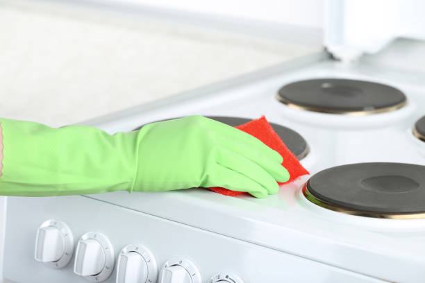 istock Hand in glove with sponge cleaning electric stove 2197576146