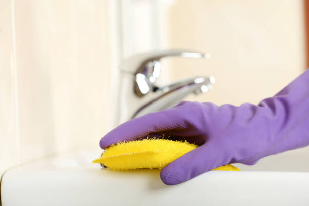 istock Hand in glove cleaning water tap in bathroom 2197576370