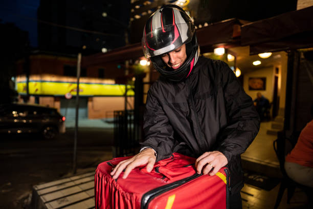 Delivery man closing his backpack outdoors