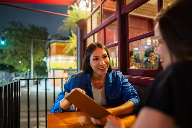 istock Female friends talking about the bill in a restaurant 2197576649