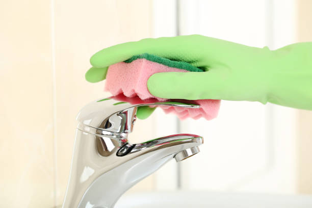 istock Hand in glove cleaning water tap in bathroom 2197576757