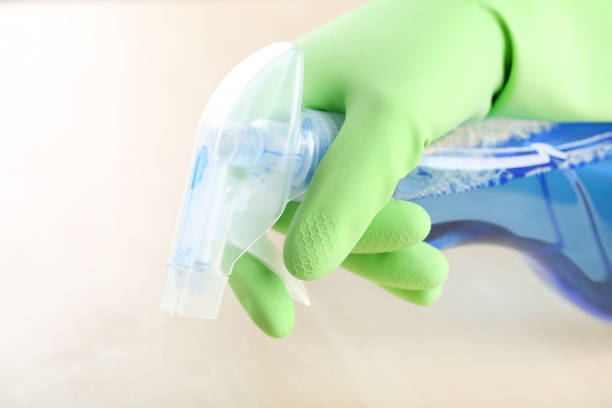 istock Hand in glove with bottle of detergent cleaning kitchen table 2197579714
