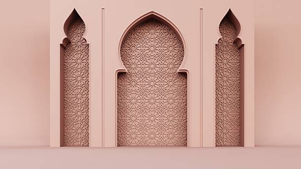 This image shows a classic Marrakesh architectural structure distinguished by its soft pink exterior, repeating archways, wooden window screens and detailed stone carvings above the entrance. The building reflects the city’s characteristic Moorish and Andalusian influences, visible in its geometric ornamentation and column designs. Palm trees and garden greenery frame the façade, adding to the warm and vibrant atmosphere typical of Marrakesh’s urban landscapes. This visual context highlights the blend of tradition, craftsmanship and color that defines much of Morocco’s architectural identity, making it suitable for themes related to culture, tourism and regional design aesthetics.