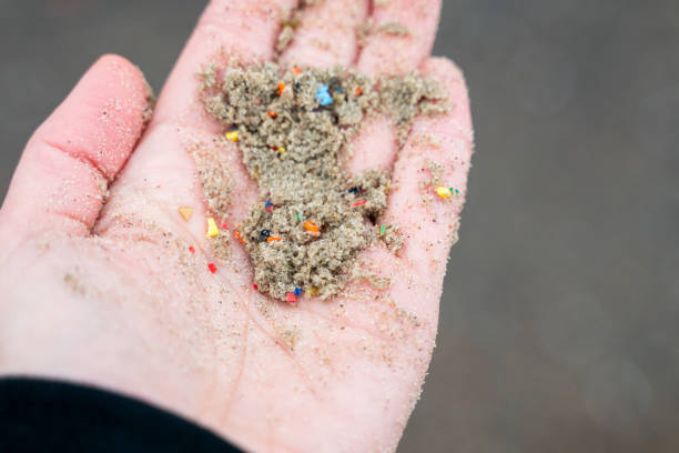 istock Extreme close-up of hand holding sand mixed with microplastic 2197582787