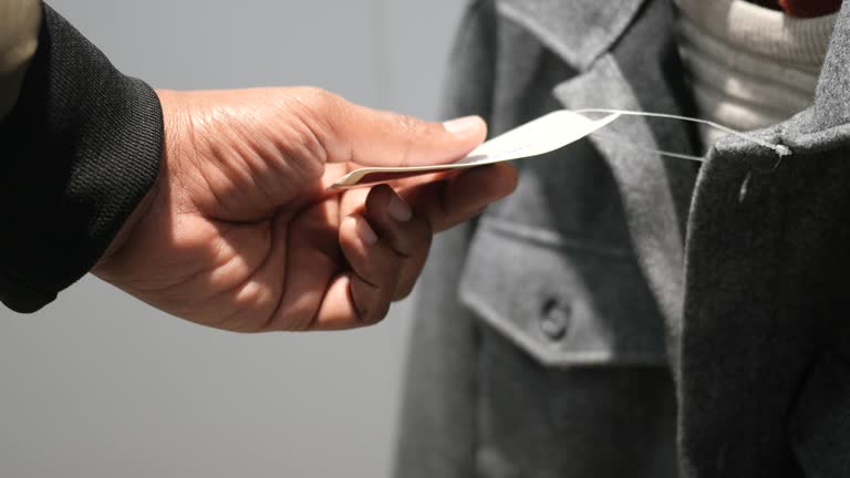 Man examining price tag on grey coat in retail store
