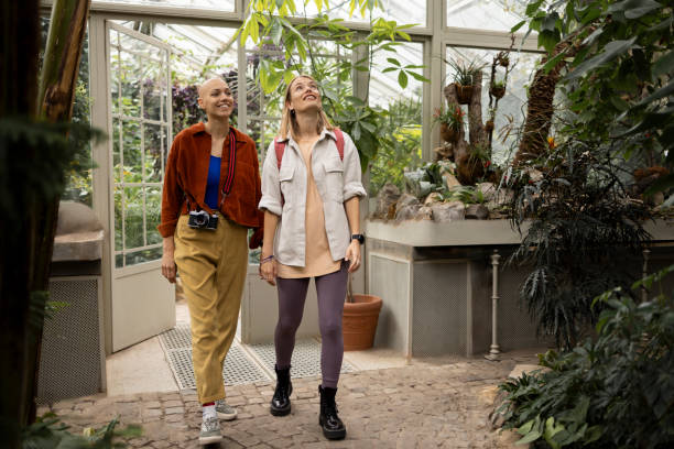 istock Two tourists holding hands while walking in botanical garden 2197583359