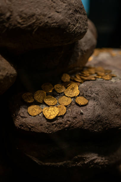 istock Colonial Era Gold Coins Resting on Large Rocks Like Discovered Treasures 2197583939