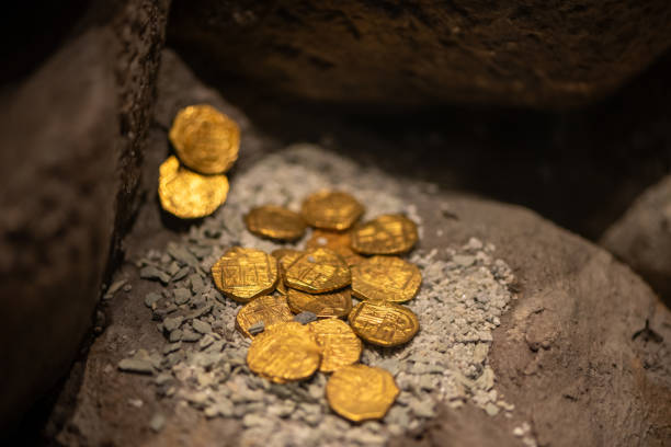 istock Authentic Colonial Gold Coins Resting on Ancient Rocks Like Discovered Treasures 2197583959