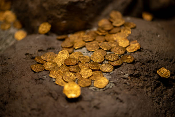 istock Ancient Colonial Gold Coins Scattered on Weathered Stones 2197583963