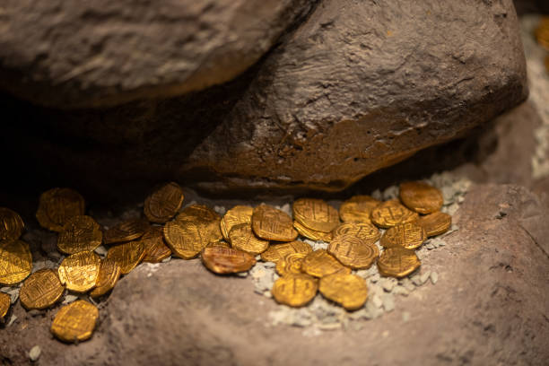 istock Ancient Colonial Gold Coins Resting on Large Rocks as Hidden Treasure 2197583975