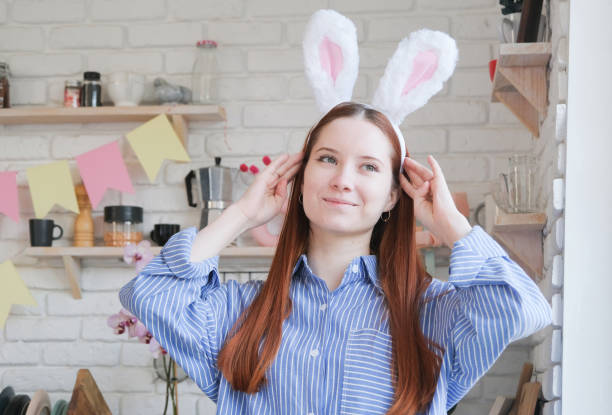istock Caucasian woman in bunny ears standing by serving table for Easter dinner 2197585753