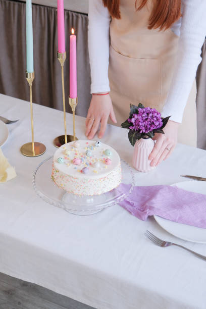 istock Caucasian woman serving table for Easter dinner, putting spring flowers 2197586840
