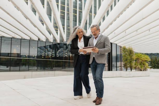 istock Couple walking and engaging with a tablet 2197587211