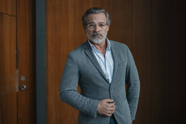 istock Charming man standing casually by wooden wall 2197587890