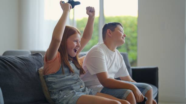 istock Children Holding Game Controllers and Playing Video Games 2197587947