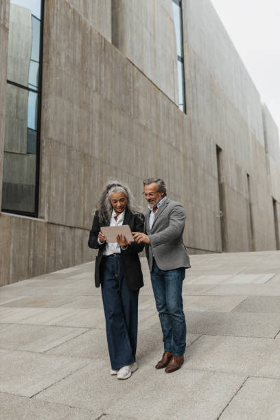istock Couple Reviewing Digital Content Outdoors Together 2197589200