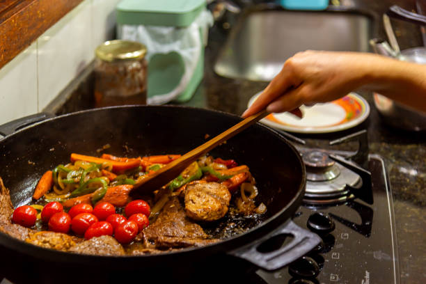 istock Steak with onions and red tomatoes being prepared in a residential kitchen. 2197589371