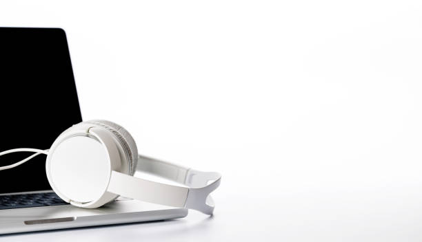 istock A headphones resting on a laptop, set against a bright white background 2197590845
