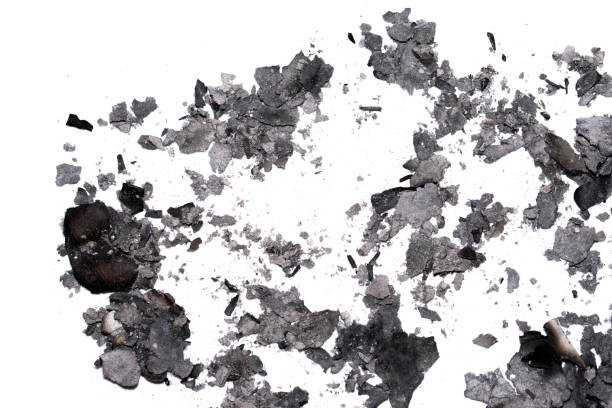 Scattered burnt ashes and debris on a white background