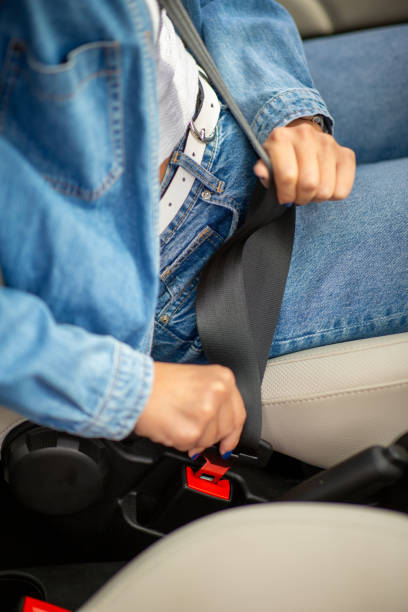 istock Close up female hands adjusting seat belt buckle 2197594977