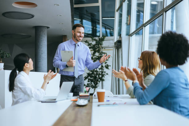 istock Manager presenting to applauding colleagues 2197595063