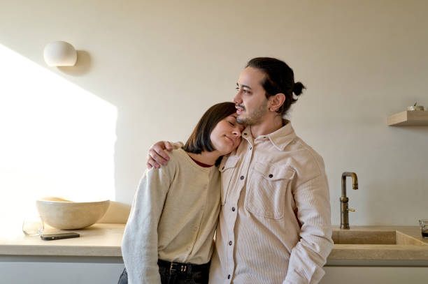 istock Young couple embracing in modern kitchen 2197597437