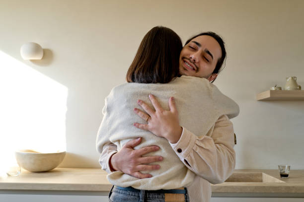 Young adults sharing a warm embrace at home