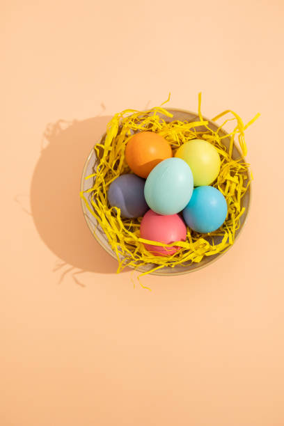 istock Vertical top view image of multi colored easter eggs placed in a nest on a light background 2197597634