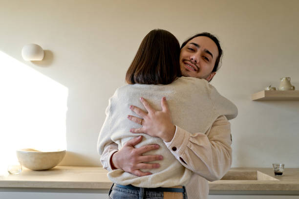 istock Young adults embracing in a minimalist kitchen 2197597648