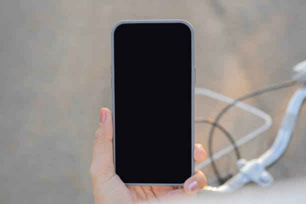 istock Woman hand hold smartphone mockup or greetings in video chat while cycling 2197598319