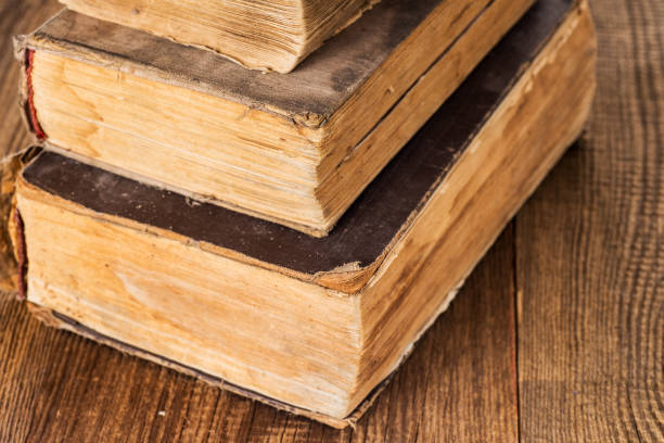 istock stack of three vintage shabby books on an old wooden table. Copy space 2197601117