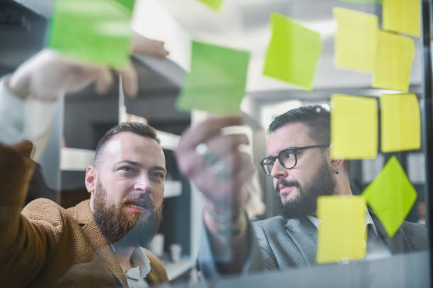 istock Male Colleagues Discussing Ideas and Notes After Business Meeting 2197601674