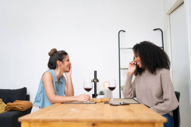 istock Lesbian couple drinking wine at the dinner table 2197603891