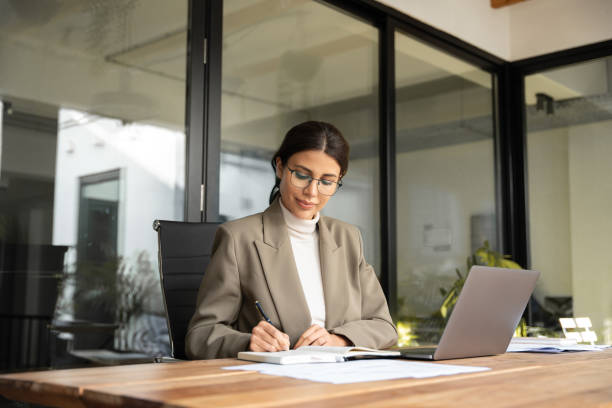 istock Middle-age Latin Hispanic woman using laptop computer for business studying, watching online virtual webinar training meeting, video call. Focused young Indian businesswoman work in office, copy space 2197605683