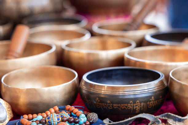 istock Polished brass Tibetan singing bowls featuring decorative inscriptions, with vibrant beaded jewelry and meditation tools arranged nearby 2197606053