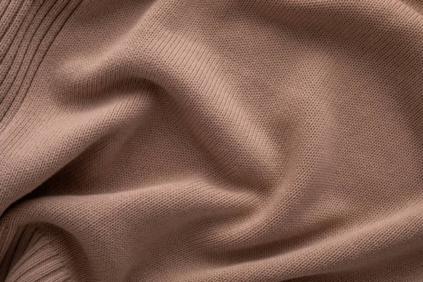 istock Soft brown knitted fabric draped elegantly over a surface showcasing texture and warmth in natural light 2197608892