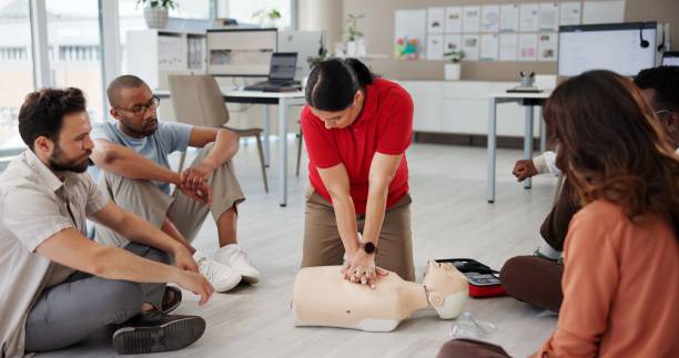 First aid, cpr training or people with dummy for safety compliance, health or chest compression for breathing. Paramedic course, medical demonstration or teaching emergency rescue technique in office