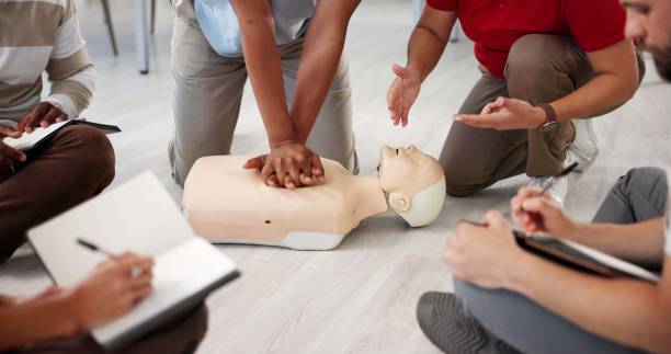 istock People, mannequin or hands in office for CPR, first aid workshop or chest compression lesson. Colleagues, emergency practice or dummy in agency for life saving procedure, notes or employee engagement 2197609557