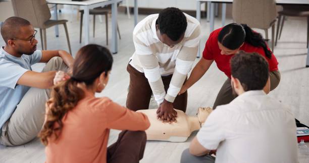 People, dummy and first aid in office for learning, CPR workshop or chest compression lesson. Design team, emergency practice or mannequin in agency for life saving procedure with employee engagement People, dummy and first aid in office for learning, CPR workshop or chest compression lesson. Design team, emergency practice or mannequin in agency for life saving procedure with employee engagement cpr stock pictures, royalty-free photos & images