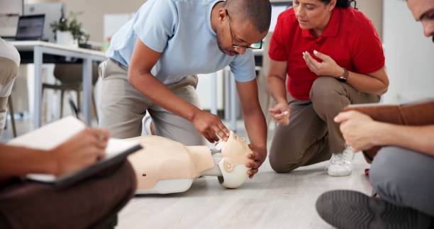 istock People, mannequin and training in office for first aid, CPR workshop or choking prevention lesson. Team, emergency practice or dummy in agency for open airways procedure, notes or employee engagement 2197609560