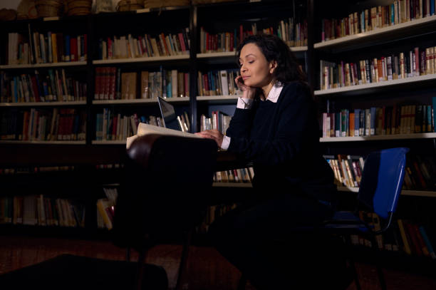 istock Person Studying in a Library Surrounded by Bookshelves 2197609612