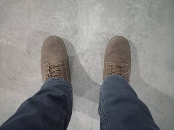 istock legs in jeans and work boots on the concrete floor 2197613526