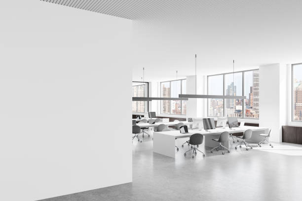 istock Empty white wall in modern open office interior with city view and workstations in bright daylight. 3D Rendering 2197616828