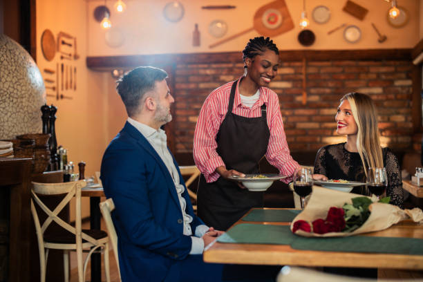 istock A server attending to a couple enjoying a quiet, romantic dinner 2197616894