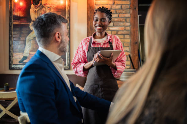 istock An elegant couple selecting their dishes while a warm and attentive waitress assists them 2197616941