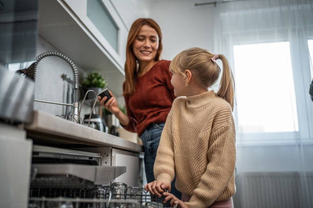 istock Mother and daughter arranging dishes together 2197617776