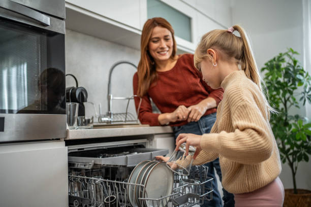 istock Mother and daughter arranging dishes together 2197617907