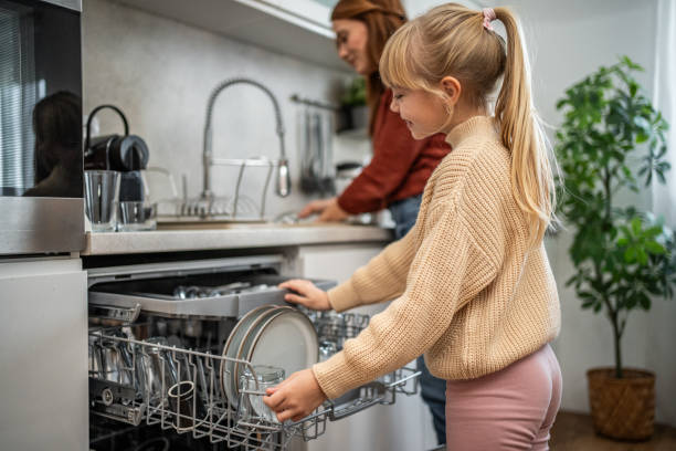istock Mother and daughter arranging dishes together 2197617909