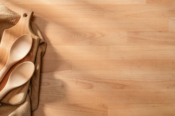 istock Wooden culinary background with two spoons, cutting board and a tablecloth at the left border making a frame and leaving copy space 2197618052