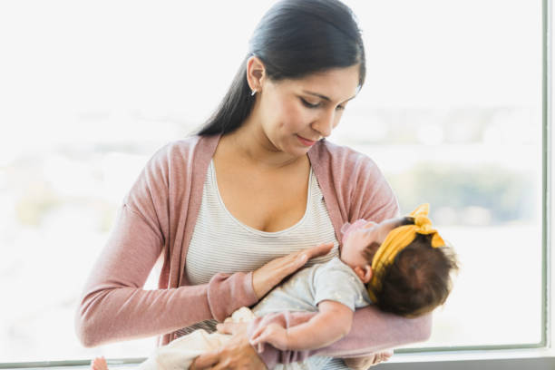 istock Tender Mother Holding Sleeping Baby Near Window 2197618075